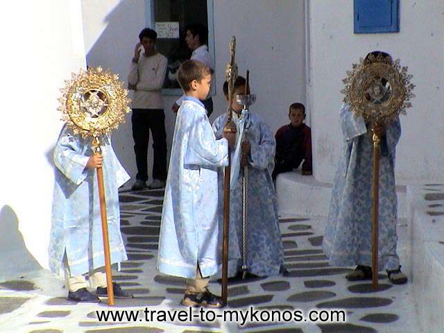 MYKONOS CHORA - The acolytes hold the exapteryga(a religion symbol of orthodoxe) and prepare to follow the procession of an icon.